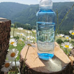 Kavo Flasche in den Alpen mit Blumen und Natur