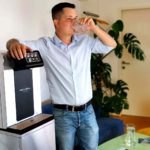 Leitungsgebundener Wasserspender Soda Premium Mitarbeiter Trinkt aus Wasserglas