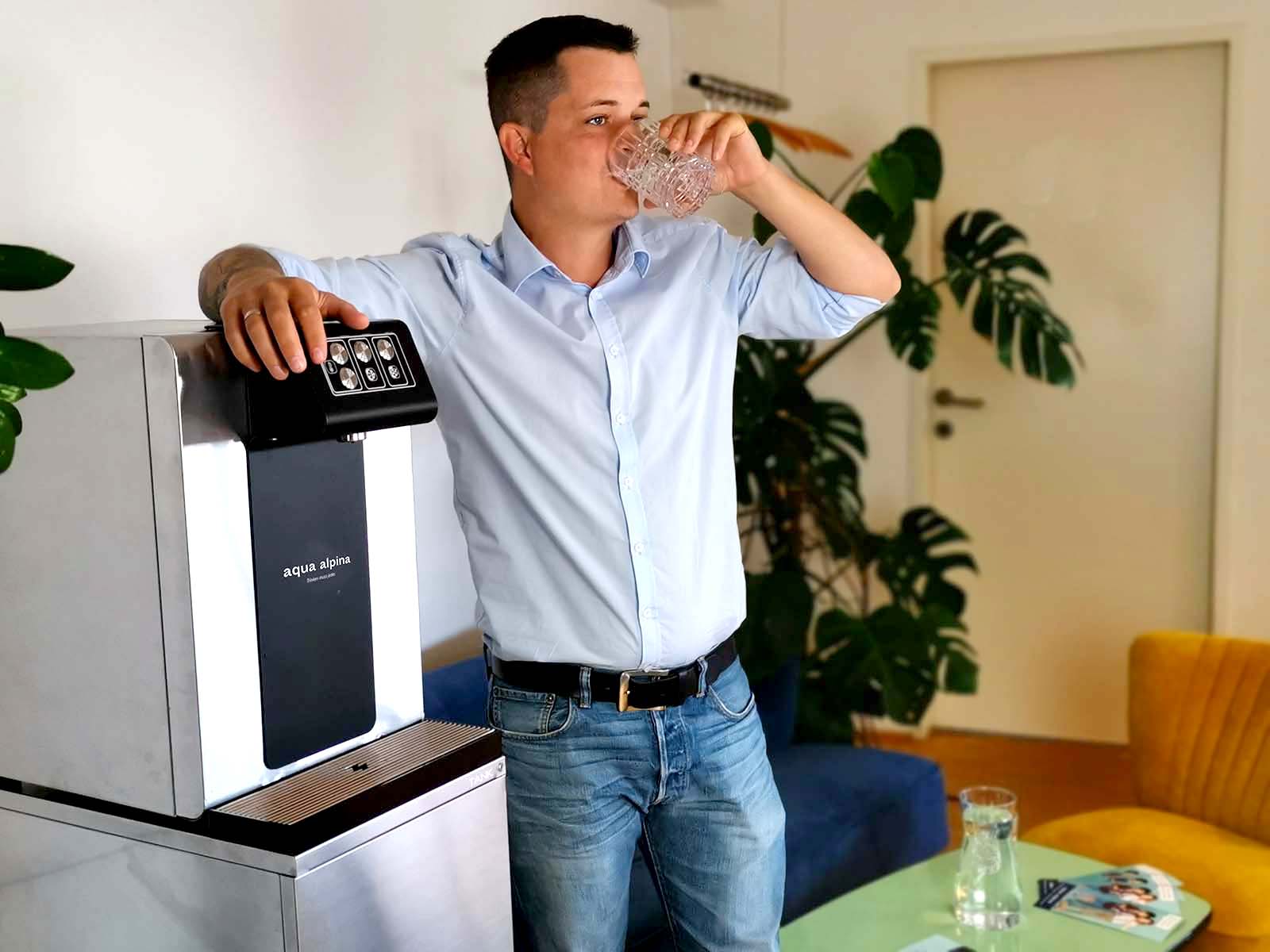 Leitungsgebundener Wasserspender Soda Premium Mitarbeiter Trinkt aus Wasserglas